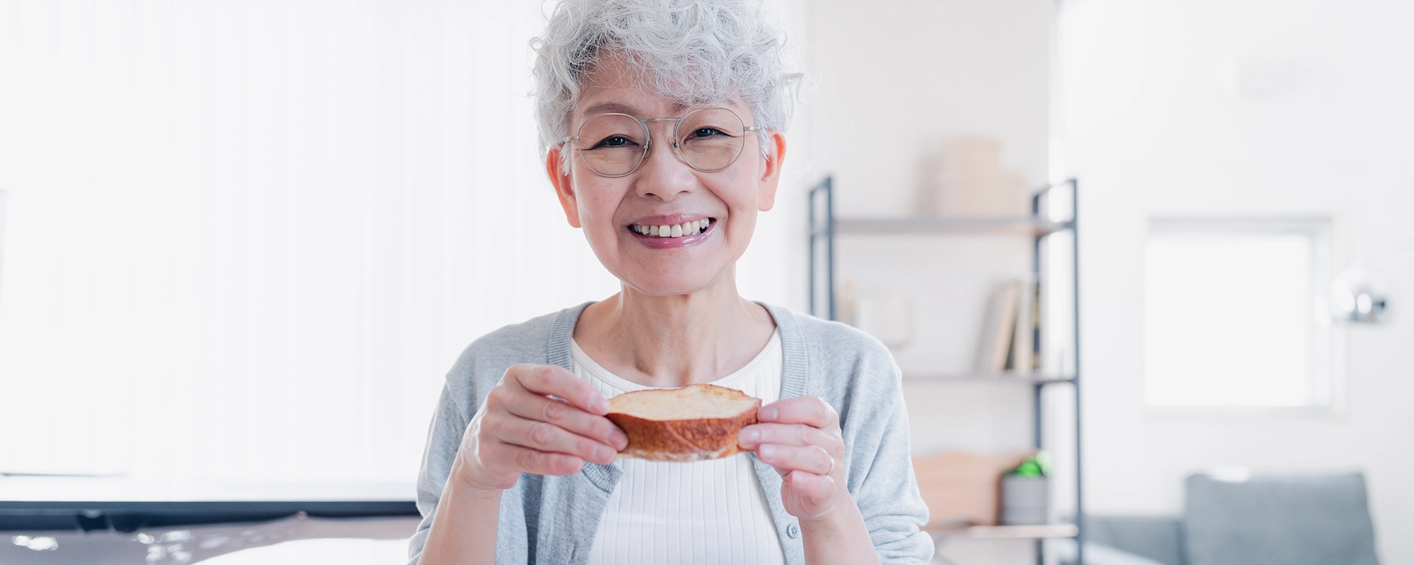 入れ歯を手にする高齢の女性